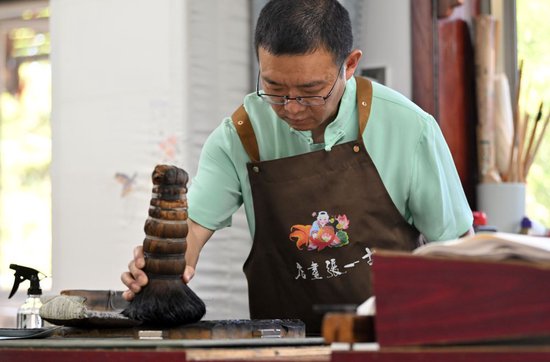  霍树林在天津市西青区的杨柳青霍氏古一张画店进行刷墨（6月6日摄）。