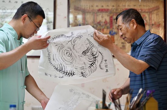 在天津市西青区的杨柳青霍氏古一张画店，霍树林（左）和父亲霍庆有交流下一阶段的年画制作（6月6日摄）。