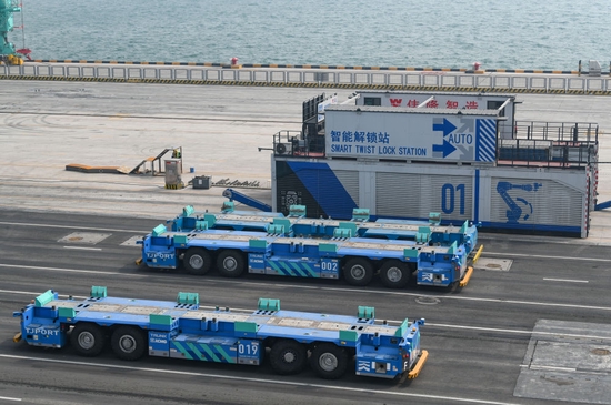 ↑4月9日，这是在天津港北疆港区C段智能化集装箱码头拍摄的智能水平运输机器人和智能解锁站。