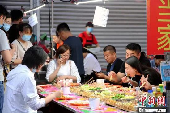 资料图：济南市民在小吃摊大饱口福。孙宏瑗 摄