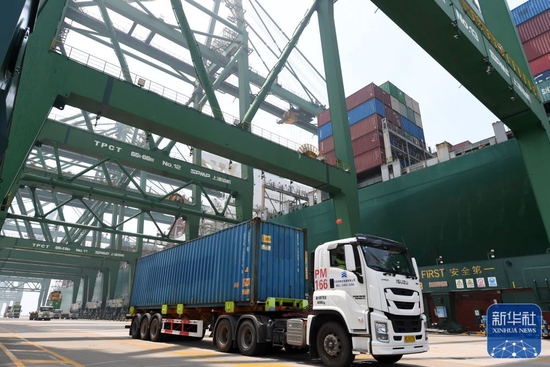 ↑7月14日，卡车在天津港太平洋国际集装箱码头运输集装箱。新华社记者 赵子硕 摄