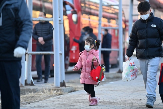 ↑1月16日，返乡工人带着小孩在天津市北辰区宜兴埠镇准备登车返乡。