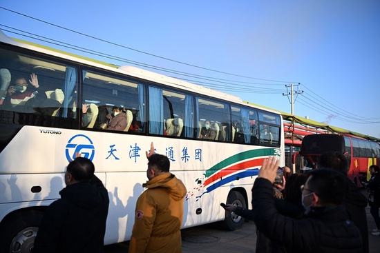 ↑1月16日，在天津市北辰区宜兴埠镇，企业人员给返乡人员送行。