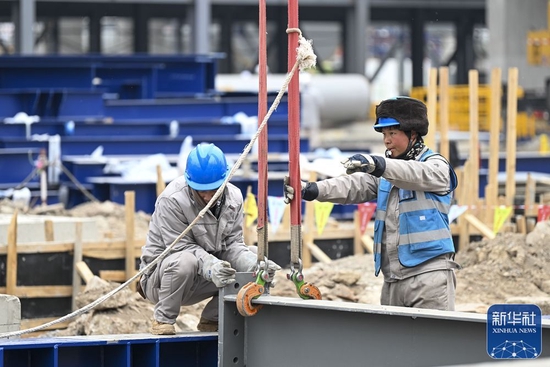 ↑2月9日，建设者在天津南港乙烯项目建设施工现场指挥起重机吊装钢梁。