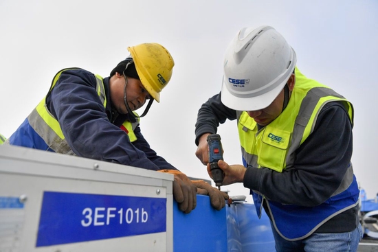 ↑在天津“细胞谷”项目建设现场，建设者在屋顶安装外部通风管保温材料（2月10日摄）。