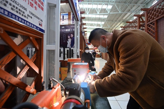 在中新天津生态城第三社区中心，一家开锁行经营者正在为顾客配钥匙。新华社记者 赵子硕 摄