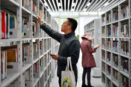 ↑ 4月21日，在天津市河西区文化中心，读者在图书馆内查阅书籍。