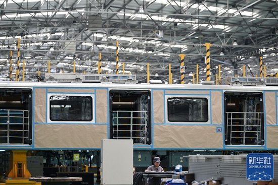 工作人员在天津中车唐车轨道车辆有限公司的组装车间内进行作业（6月20日摄）。