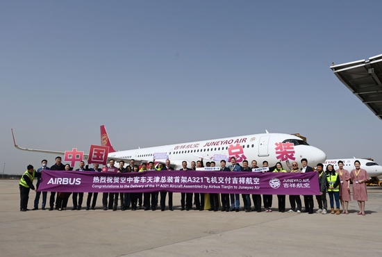 3月24日，参加交付仪式的空中客车和吉祥航空工作人员在A321飞机前合影。新华社记者赵子硕摄