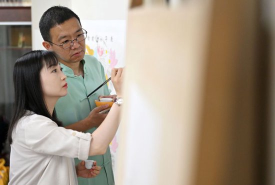 在天津市西青区的杨柳青霍氏古一张画店，霍树林（右）和妻子王丹一起进行彩绘（6月6日摄）。