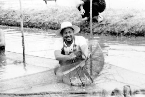 20世纪60年代，金万昆在鱼塘中劳动（资料照片）。新华社发