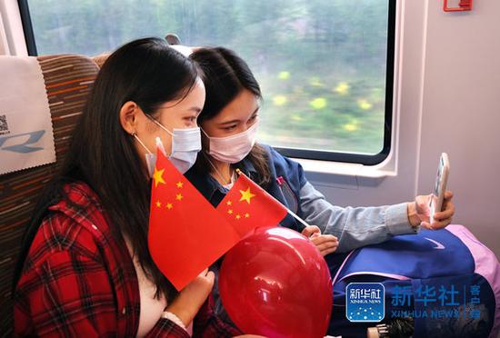 10月1日，乘坐京津城际C2020次列车的旅客在车厢内用手机自拍留影。（杨宝森  摄）