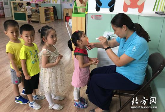 幼儿园保健医生检查幼儿咽部、手部掌侧着力部位是否有疱疹