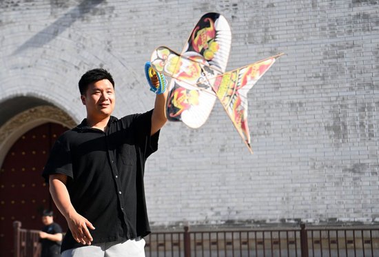 在天津市鼓楼附近，魏博文在放飞一架制作完成的风筝（6月8日摄）。