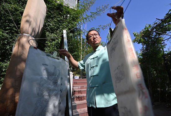 在天津市西青区的杨柳青霍氏古一张画店，霍树林把印好的“画坯子”进行晾晒（6月6日摄）。