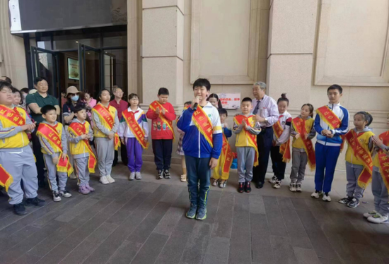 “红色故事宣讲员” 利用休息时间,身披红色绶带,为一批批游人进行讲解