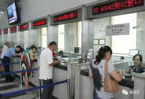 2012年7月,市民正在银行窗口办理业务。张磊 摄