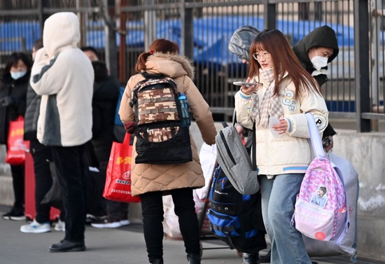 ↑1月16日，返乡工人在天津市北辰区宜兴埠镇等待车辆到达。