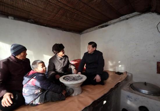 2012年12月30日,习近平坐在龙泉关镇骆驼湾村困难群众唐荣斌家(右二)炕上,详细询问他们一年下来有多少收入,粮食够不够吃,过冬的棉被有没有,取暖的煤炭够不够,小孩上学远不远,看病方便不方便。新华社记者 兰红光 摄