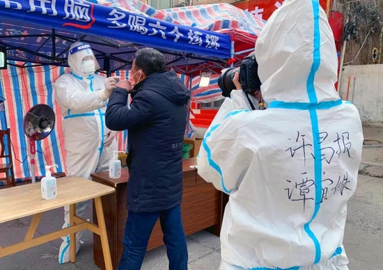 2022年1月14日,河南省禹州市开展第11轮全员核酸检测,许昌日报社记者谭宜姝在该市颍川街道办事处东关社区核酸检测现场采访。