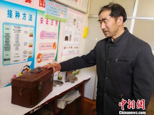 焦宽俊为记者介绍当年行医背过的药箱。高展 摄