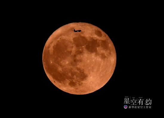 2022年6月14日,在土耳其伊斯坦布尔,一架飞机飞过年度第二大满月。(新华社记者沙达提 摄)