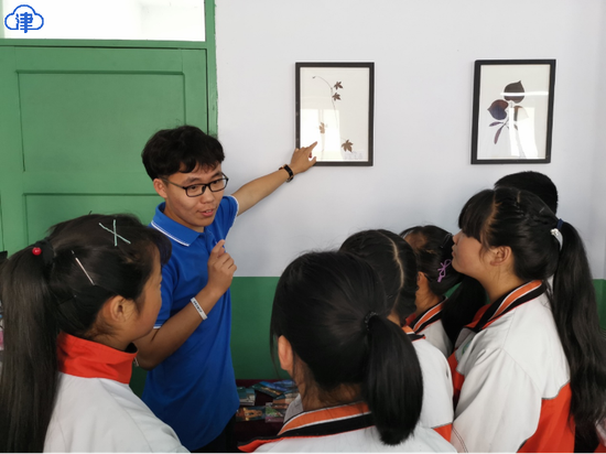 暑期实践队队员向孩子介绍自己采集的标本