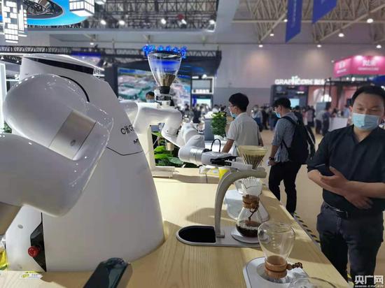 中国移动咪咕“5G“AI咖大师手冲咖啡机器人1:1复刻世界咖啡师大赛冠军咖啡,吸引了众多观众前往“尝鲜”(央广网发 张檬 摄)