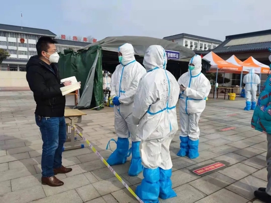 2022年1月14日,河南省安阳市汤阴县城关镇人民路社区,河南日报社安阳分社记者李旭兵(左一)进入安阳新冠肺炎确诊病例最多的汤阴县,在人民路社区现场采访参与社区服务的大学生志愿者。