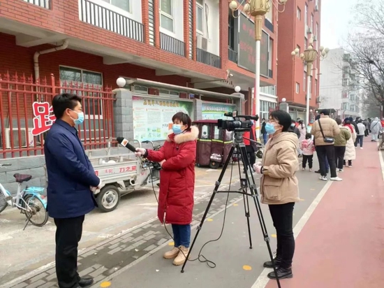 2022年1月12日,河南省安阳市殷都区开展第三轮全员核酸检测,殷都新闻记者李刘阳(右)和王晓芳(中)采访殷都区清风街道全员核酸检测工作开展情况。