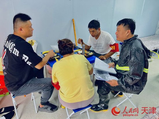 8月5日12:40,毕红鸽将取回的午餐发放给同组工作人员,他自己却无心吃饭,又细细看了一遍防汛注意事项。人民网记者 孙翼飞摄
