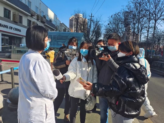 西安交通大学第一附属医院因疫情停诊,为了让封控小区内的血液透析患者能及时得到治疗,医院克服困难设立隔离病区。2021年12月21日,西安日报社记者张黎娜(右一)第一时间赶赴医院采访该院血液净化科主任。