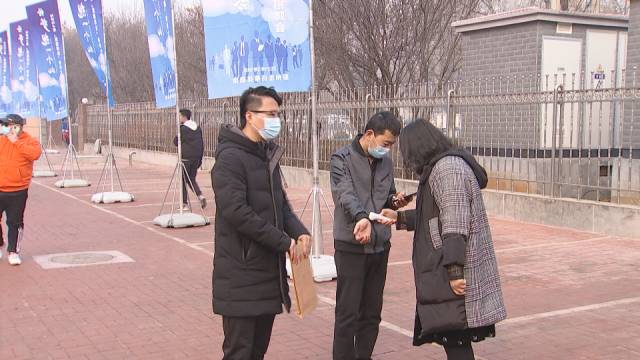 上午9点,求职者佩戴着口罩,排队扫码、测量体温后,进入会场