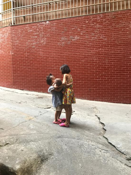 最小的妹妹被姐姐们轮流抱着。