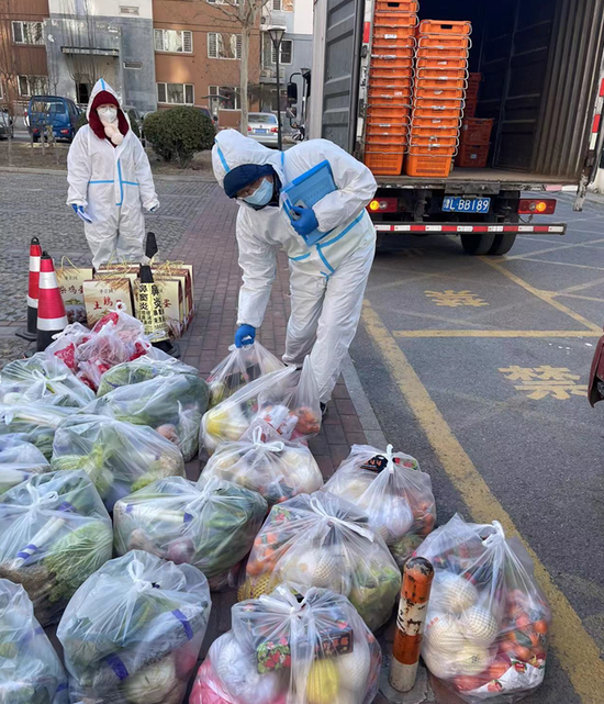 ▲陶宁和志愿者统计蔬菜、水果订单