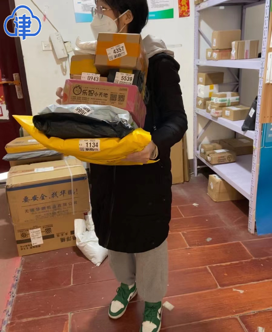 东丽区季景家园网格员周志慧在封控期间，帮助居民取送快递。