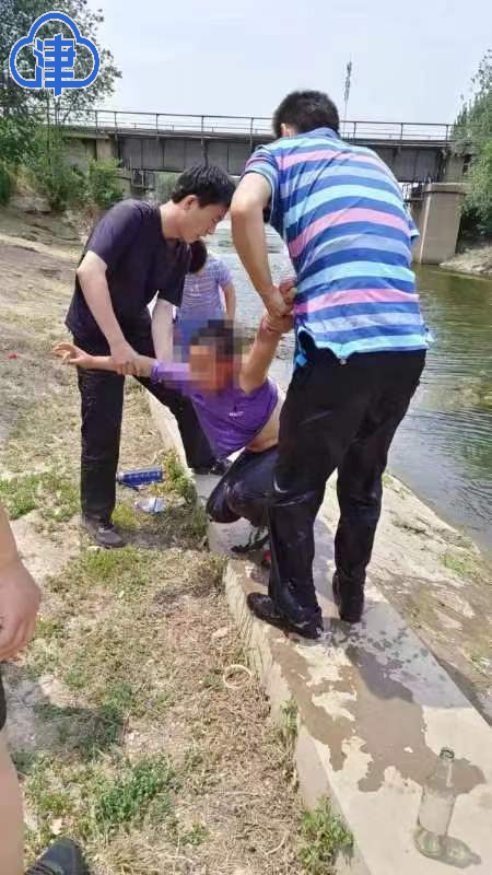 图为：西青特警队员正在为落水儿童施救