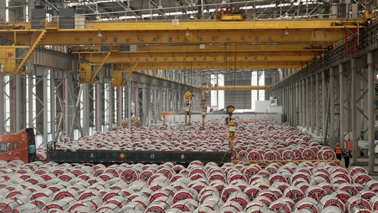 2月2日，天津市新宇彩板有限公司仓库内，机器臂将板材卷吊入卡车。新华社记者 李帅 摄