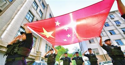 市公安特警总队民警与国旗同框。