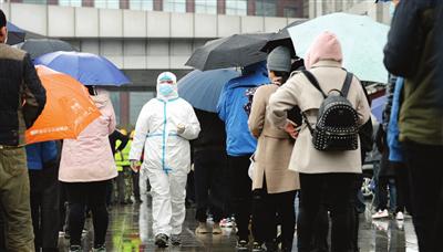 市民排起长队，在雨雪中静静地有序等待核酸检测