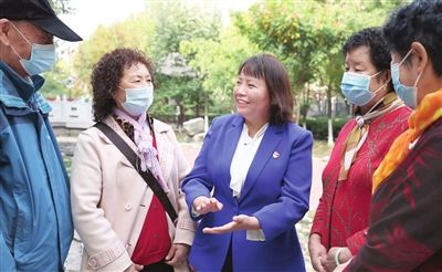 林则银(右三)与社区居民交流。 本报记者 孙立伟 摄