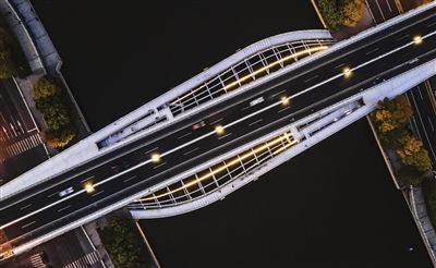 金阜桥，采用轻型非对称结构，两侧人行桥与主桥一同构成一个三维立体结构，犹如横跨海河的“时空隧道”。