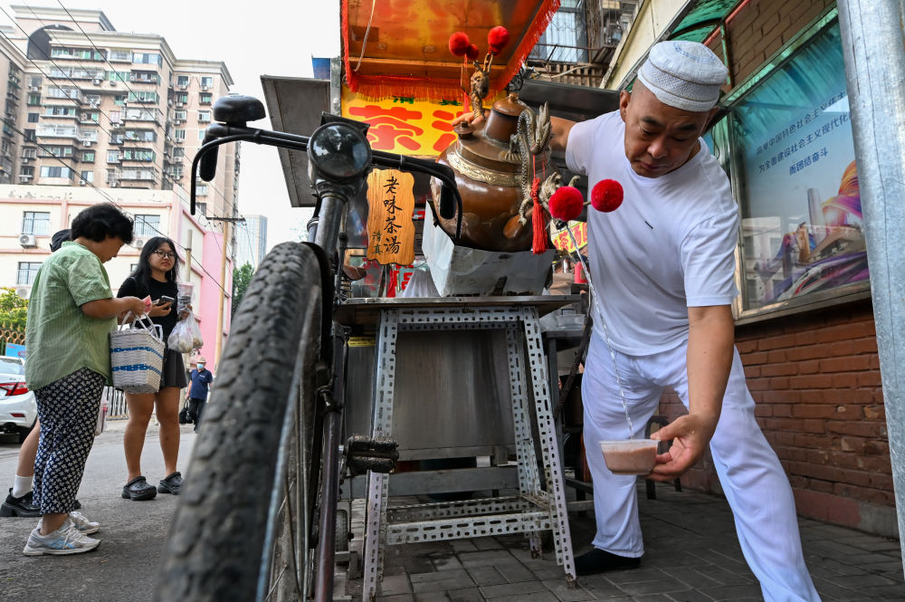 7月11日，商家在天津西北角欢庆西胡同制作老味茶汤。新华社记者 孙凡越 摄