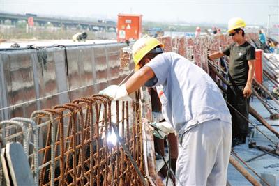 施工人员焊接主桥附属护栏