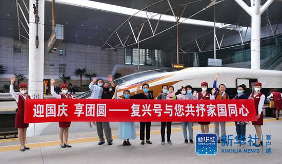 10月1日，乘务人员与旅客在天津站站台合影留念。（杨宝森  摄）