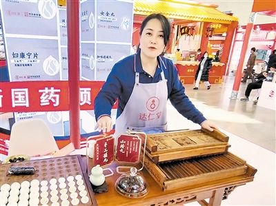 工作人员向观众介绍天津传统的工艺——手工搓丸制作的山楂丸。