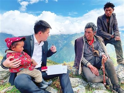 西藏昌都贡觉县沙东乡金沙江畔山顶，天津市援藏干部在给当地村民做易地搬迁思想工作。（照片由市合作交流办提供）