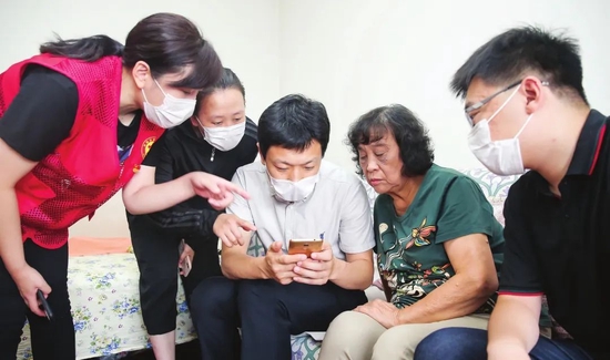 和平区党员服务组走进居民家中为居民讲解智能手机的使用。