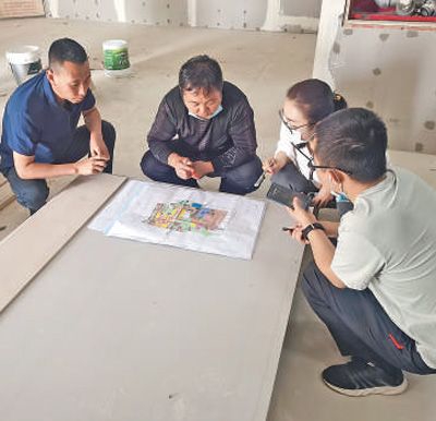 刘振兴(左一)在策勒县天津工业园区津和数字电子展馆施工现场办公。天津援疆前方指挥部供图