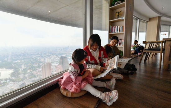↑ 4月22日，在天津市河西区天塔西岸书斋，读者在“高空书吧”里阅读书籍。